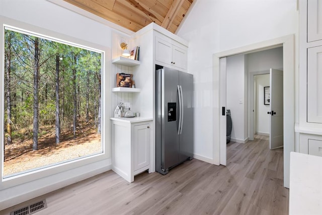 kitchen featuring wooden ceiling, white cabinets, lofted ceiling with beams, light wood-type flooring, and stainless steel fridge with ice dispenser