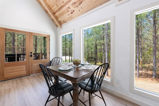 dining room with high vaulted ceiling, wood ceiling, and light wood-type flooring