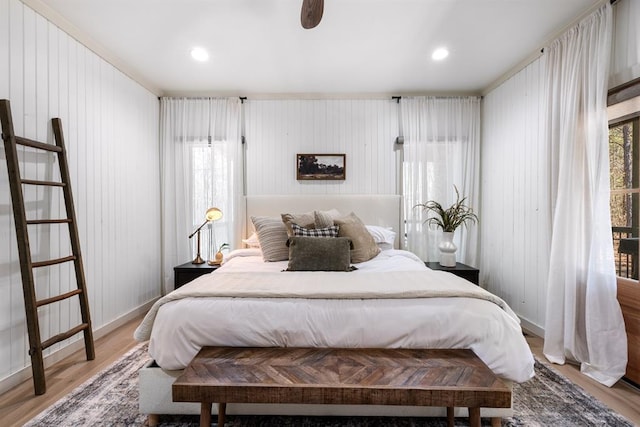 bedroom featuring hardwood / wood-style flooring and wood walls