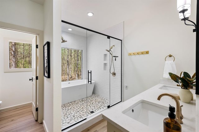 bathroom featuring vanity, hardwood / wood-style flooring, independent shower and bath, and a healthy amount of sunlight