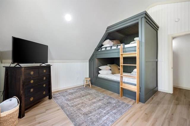 bedroom featuring lofted ceiling and light wood-type flooring