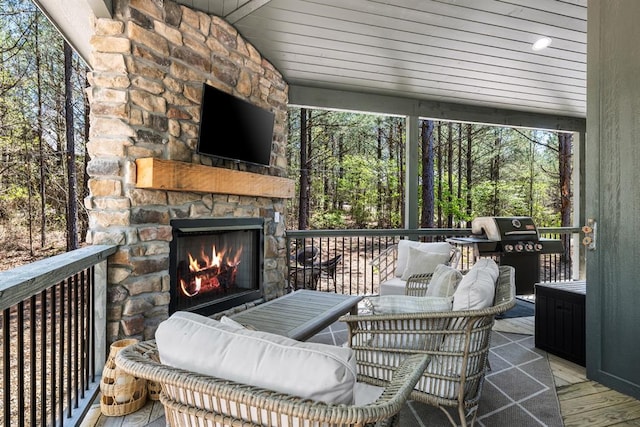 sunroom / solarium with lofted ceiling with beams, an outdoor stone fireplace, and wooden ceiling