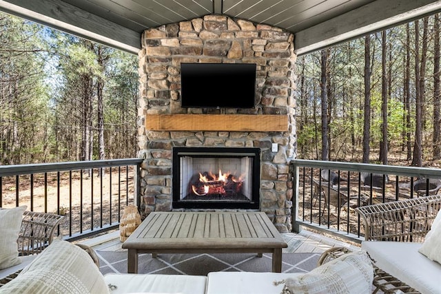 wooden terrace with an outdoor stone fireplace