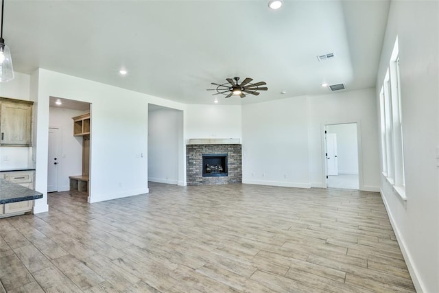 unfurnished living room featuring ceiling fan, light hardwood / wood-style flooring, and a healthy amount of sunlight