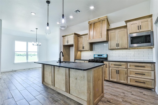 kitchen with gas stove, decorative light fixtures, stainless steel microwave, and sink