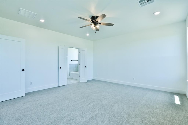 unfurnished bedroom with light colored carpet, ensuite bath, and ceiling fan