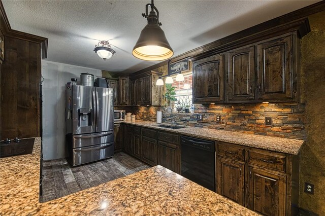 kitchen with black appliances, sink, light stone countertops, decorative light fixtures, and dark brown cabinets