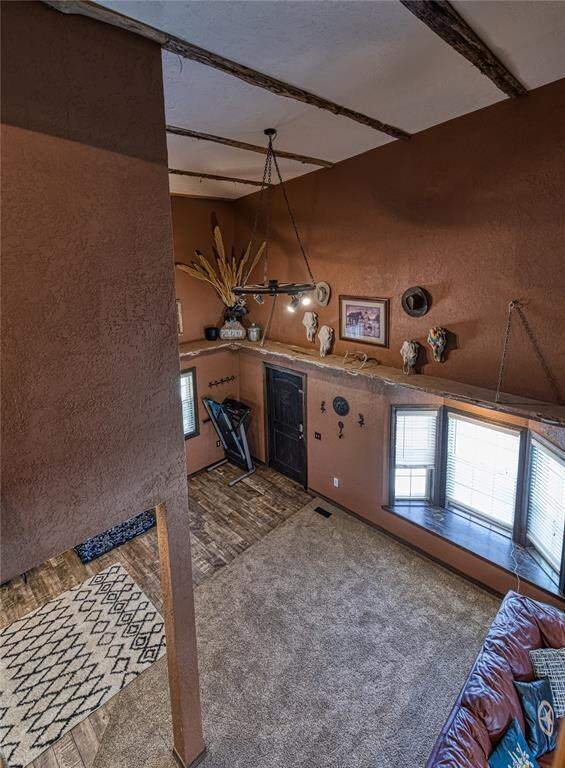 interior space featuring beam ceiling and carpet