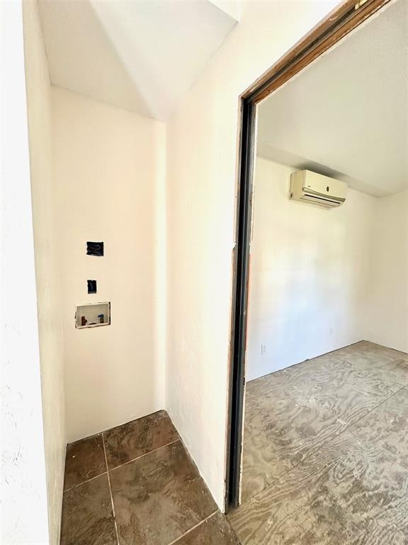 hall featuring a wall mounted air conditioner and dark tile patterned flooring