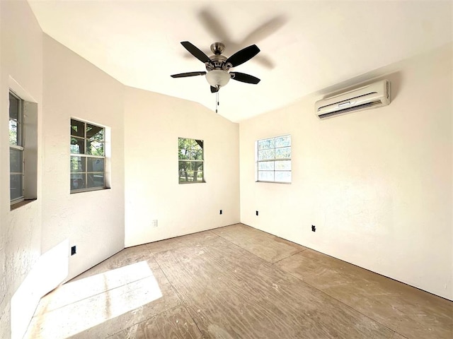 empty room with ceiling fan, vaulted ceiling, and a wall mounted AC