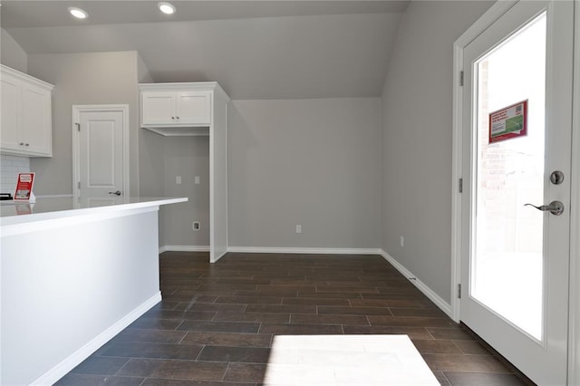 kitchen featuring decorative backsplash, white cabinetry, and vaulted ceiling