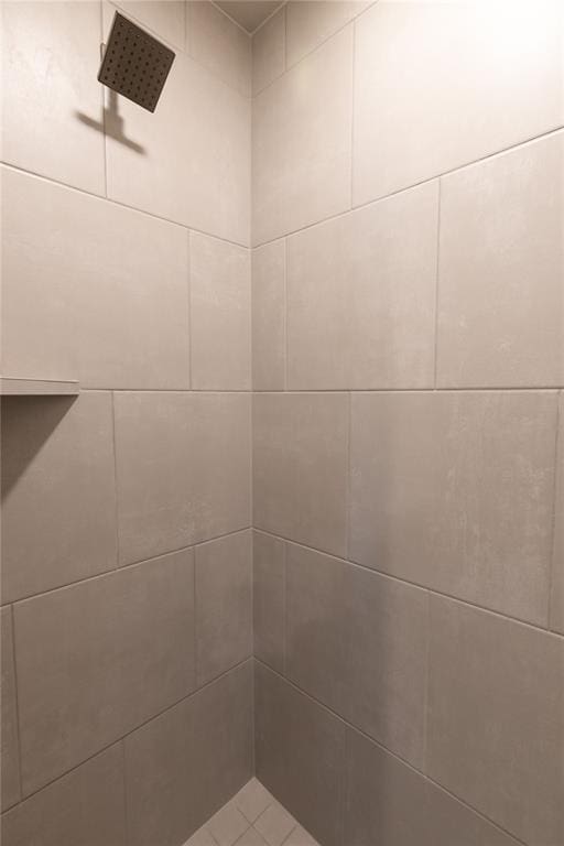 interior details featuring a tile shower