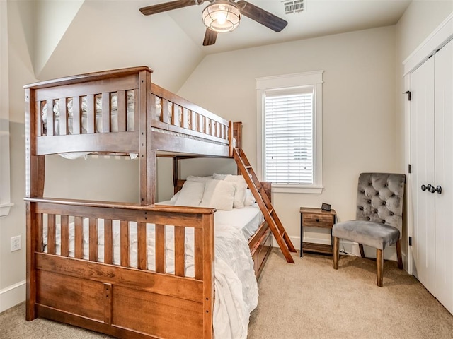 carpeted bedroom featuring ceiling fan, a closet, and lofted ceiling