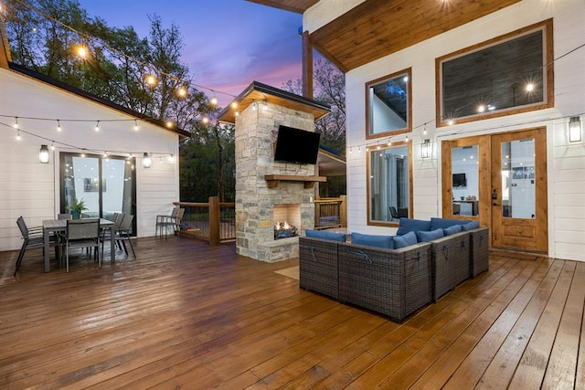 wooden deck with an outdoor living space with a fireplace