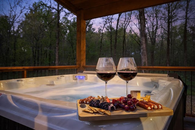 deck at dusk with a hot tub