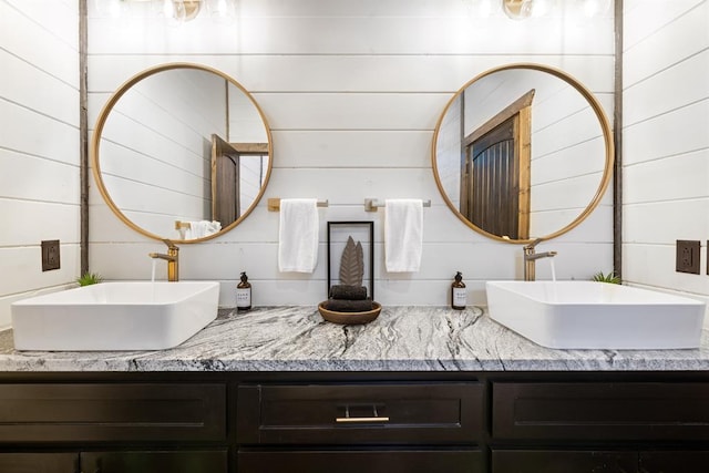 bathroom featuring wood walls and vanity