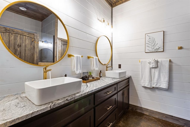 bathroom featuring wooden walls and vanity