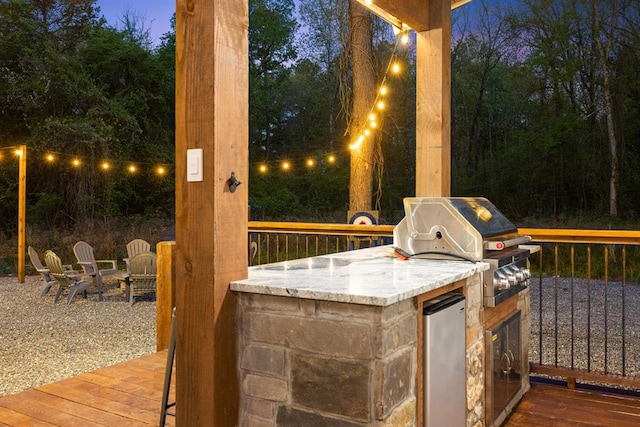 view of patio with area for grilling and a wooden deck