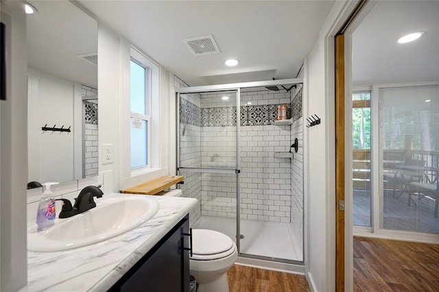 bathroom with toilet, vanity, a healthy amount of sunlight, and hardwood / wood-style flooring