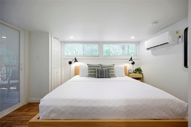 bedroom featuring a wall mounted air conditioner, wood-type flooring, access to outside, and multiple windows