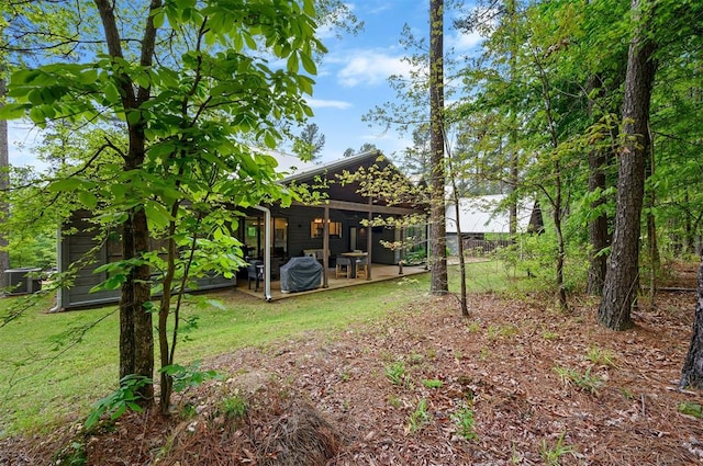 view of yard with central air condition unit and a patio