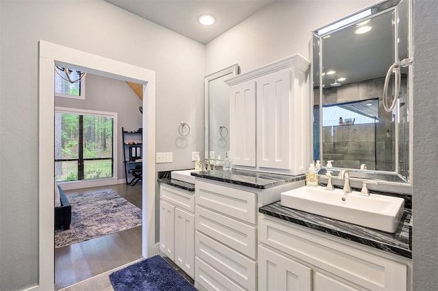 bathroom with hardwood / wood-style floors, vanity, a healthy amount of sunlight, and walk in shower