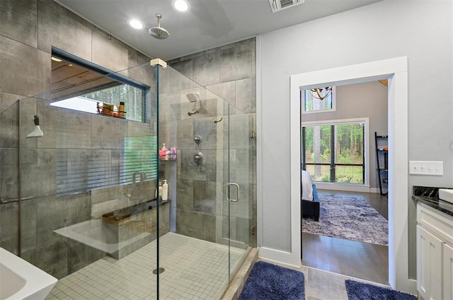 bathroom featuring a shower with door, vanity, and wood-type flooring