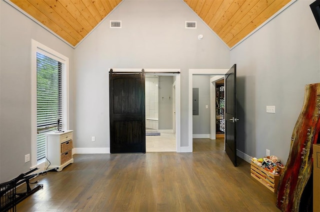 unfurnished bedroom with dark hardwood / wood-style flooring, a barn door, crown molding, and wood ceiling