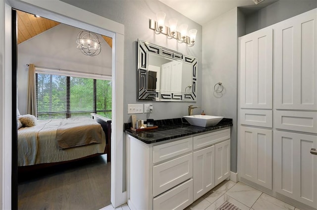 bathroom with vanity, wooden ceiling, lofted ceiling, and a notable chandelier