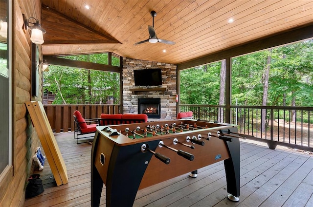 deck with a stone fireplace and ceiling fan