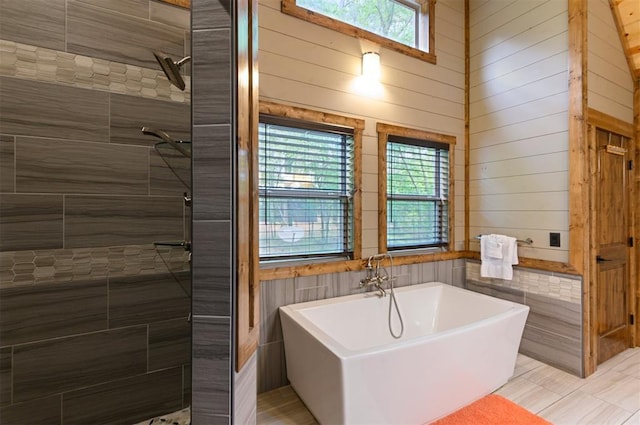 152 Ita Hina Trl, Broken Bow, OK 74728 - bathroom with plenty of natural light, a soaking tub, a tile shower, and wooden walls
