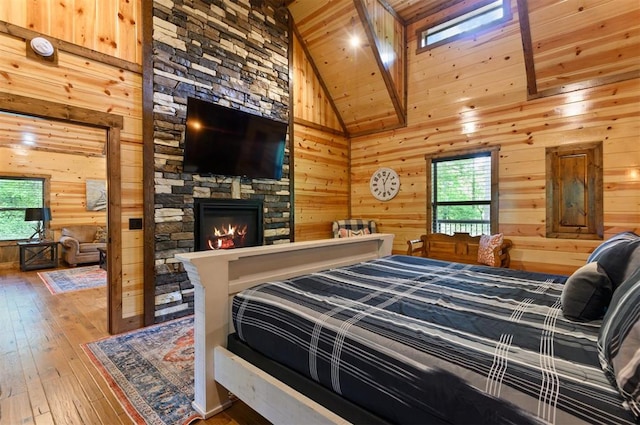 bedroom with hardwood / wood-style floors, wood ceiling, high vaulted ceiling, and multiple windows