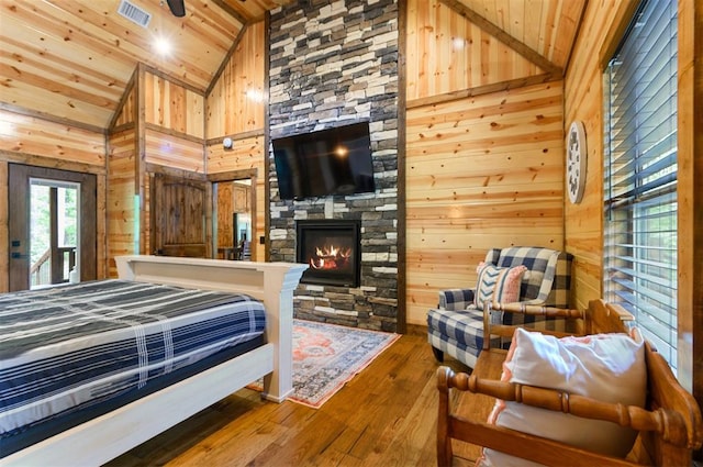 bedroom with wood-type flooring, high vaulted ceiling, wooden walls, and wood ceiling