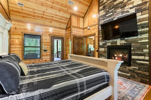 bedroom featuring hardwood / wood-style floors, high vaulted ceiling, wooden walls, a fireplace, and wood ceiling