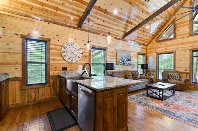 kitchen with light stone countertops, a wealth of natural light, wooden walls, beam ceiling, and dark hardwood / wood-style floors