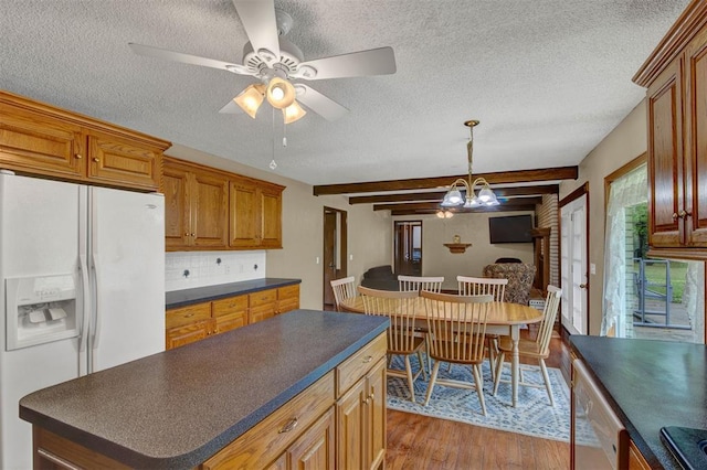 kitchen featuring beam ceiling, a textured ceiling, light hardwood / wood-style floors, and white fridge with ice dispenser