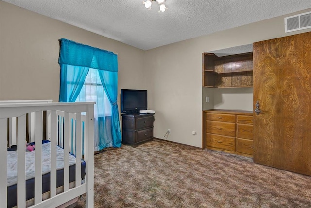 bedroom featuring carpet flooring and a textured ceiling