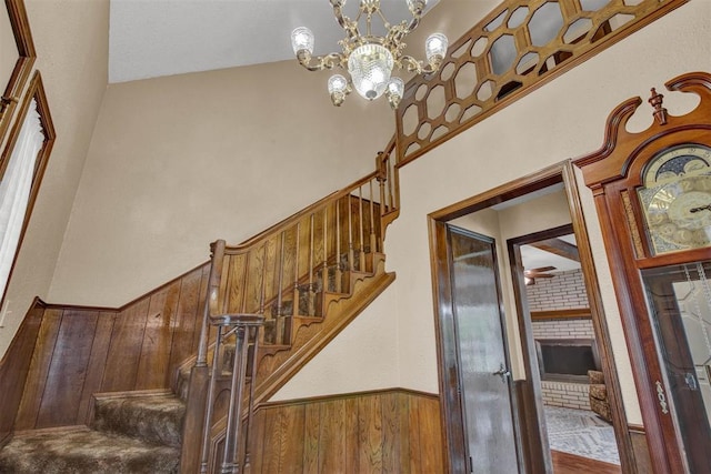 stairway featuring wood-type flooring and an inviting chandelier