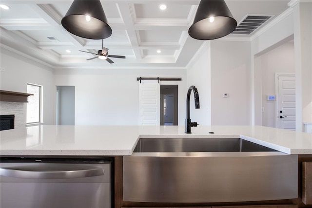 kitchen featuring coffered ceiling, crown molding, stainless steel dishwasher, a barn door, and beamed ceiling