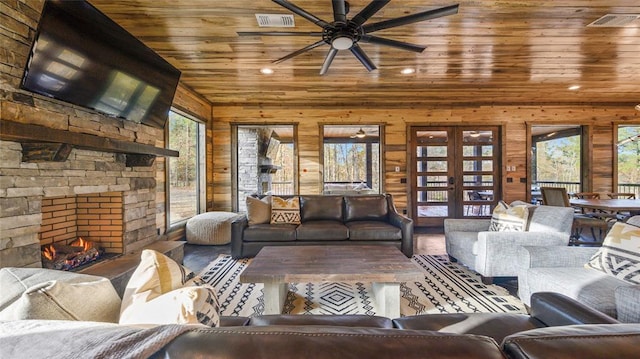 living room featuring a wealth of natural light, french doors, ceiling fan, and wood ceiling