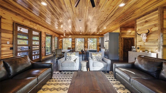 interior space with ceiling fan, wood walls, and wood ceiling