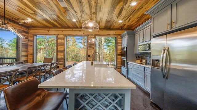 kitchen with pendant lighting, sink, decorative backsplash, appliances with stainless steel finishes, and wood ceiling