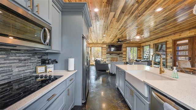 kitchen with appliances with stainless steel finishes, wood ceiling, ceiling fan, gray cabinets, and wood walls