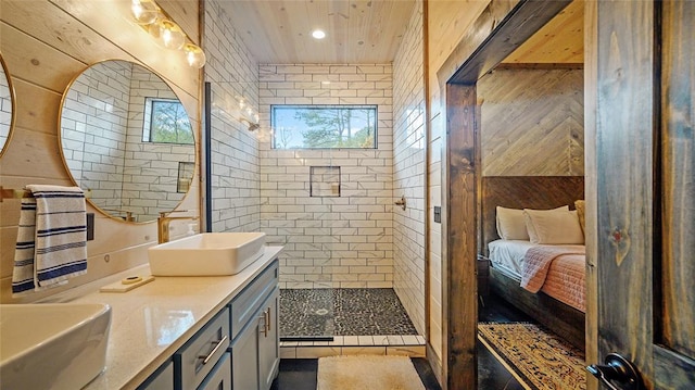 bathroom featuring a tile shower and vanity