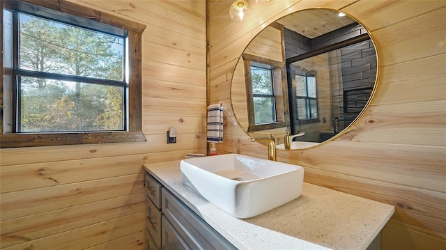 bathroom featuring vanity, a wealth of natural light, and wooden walls