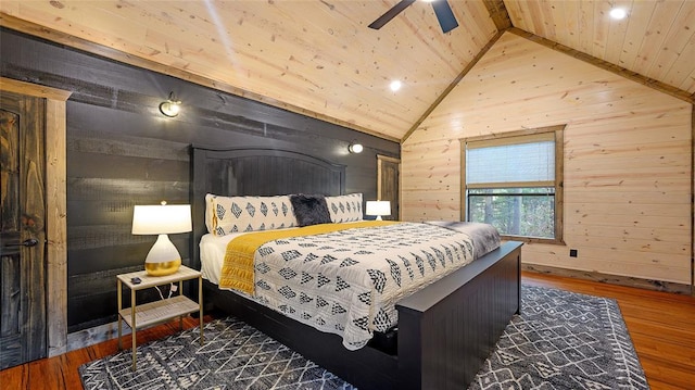 bedroom with wood walls, hardwood / wood-style floors, and lofted ceiling