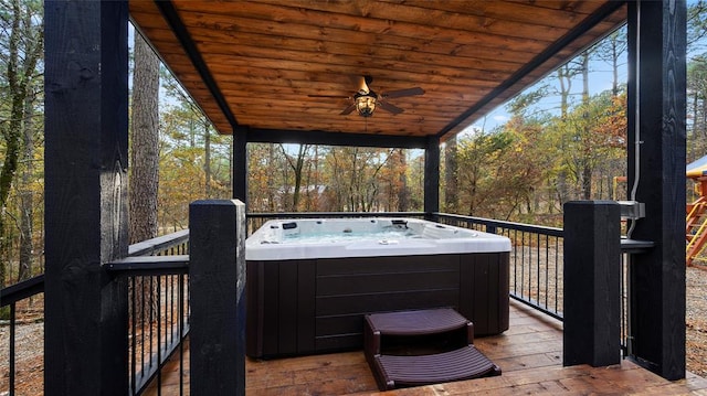 wooden deck with ceiling fan and a hot tub