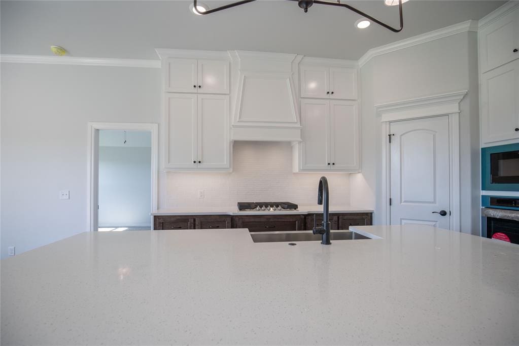 kitchen featuring sink, white cabinets, custom exhaust hood, and appliances with stainless steel finishes