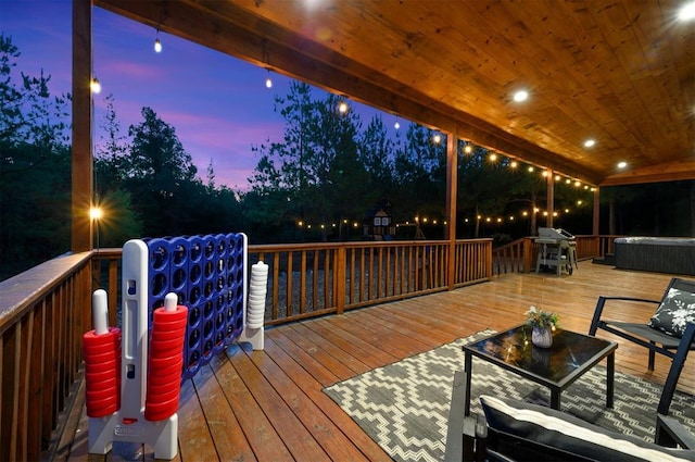 deck at dusk featuring a grill and a hot tub