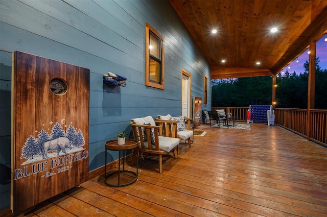 deck at dusk featuring covered porch